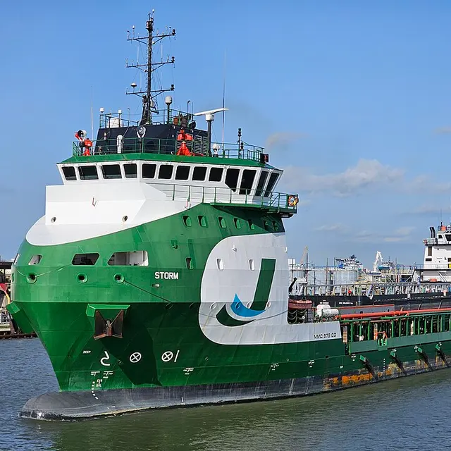 A green-and-white offshore supply vessel underway.