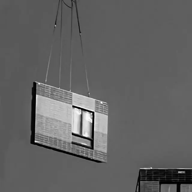 Crane slings lifting a prefabricated wall panel.