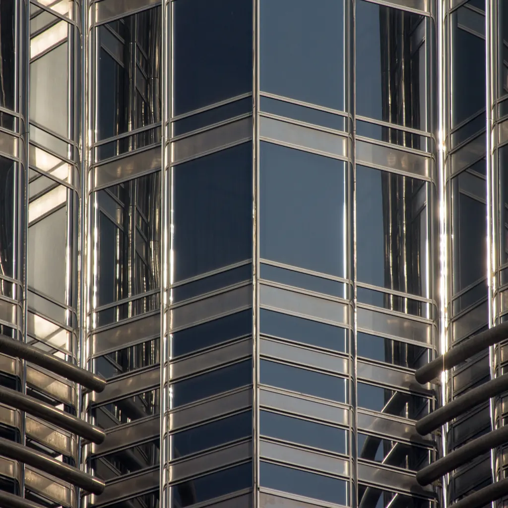 Close-up of an installed unitized glass curtain wall with reflective double-glazed panels and aluminum frames.
