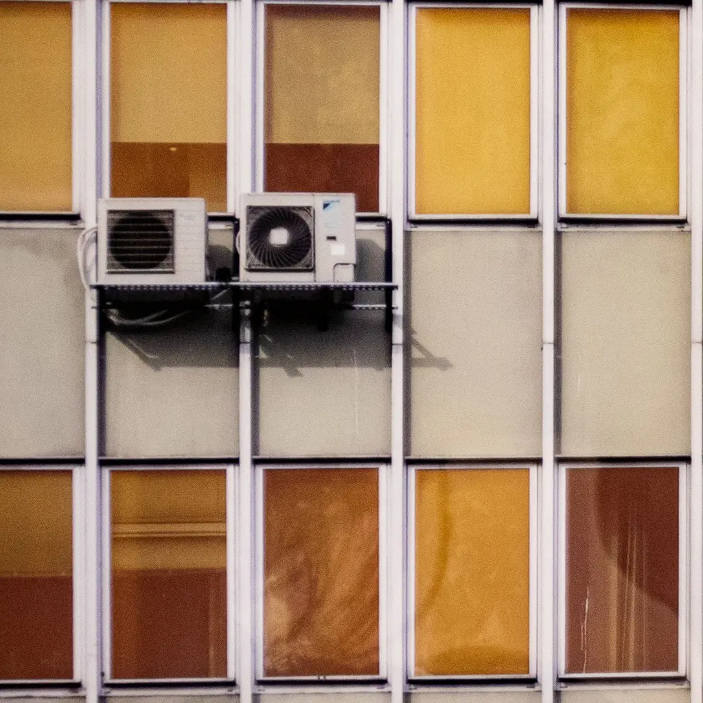 Two outdoor air-conditioning condenser units mounted together on a commercial building facade.