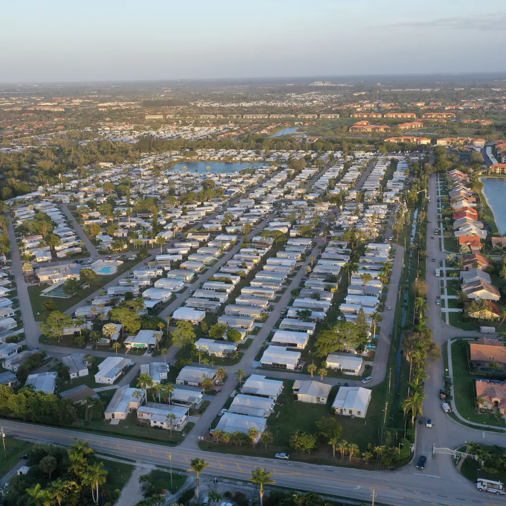 An aerial view of homes, neighborhood roads and landscaped grounds.