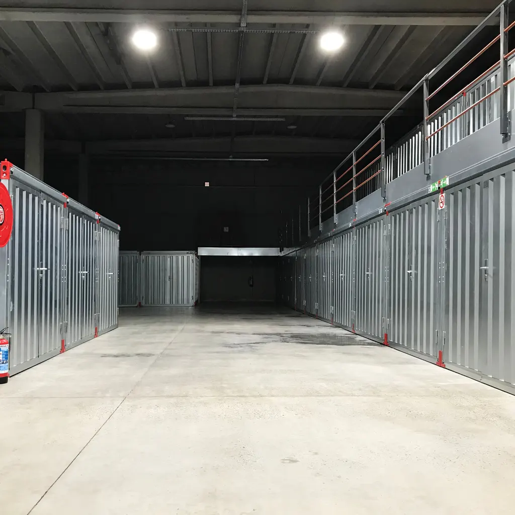 Rows of individual metal storage compartments beside a clear indoor access aisle.