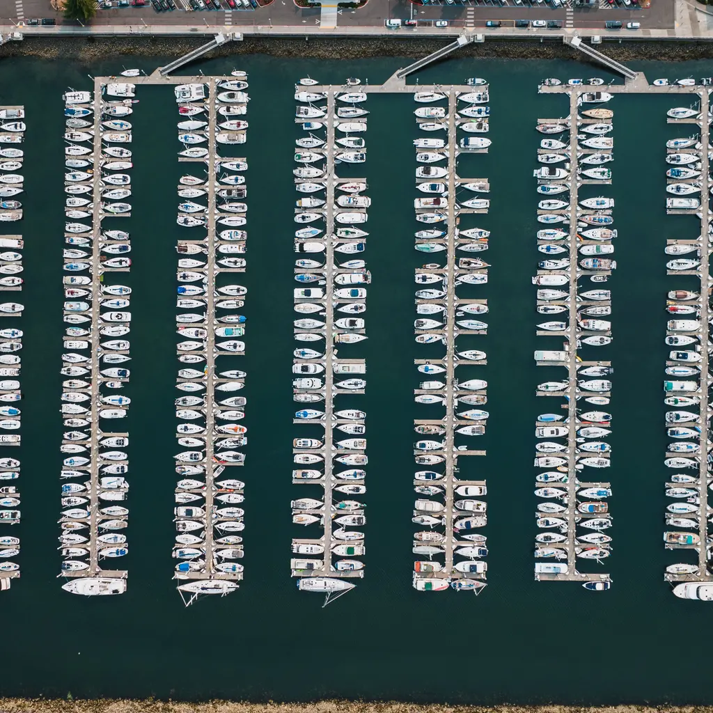 Rows of boats occupy marina slips connected by docks and shore gangways.