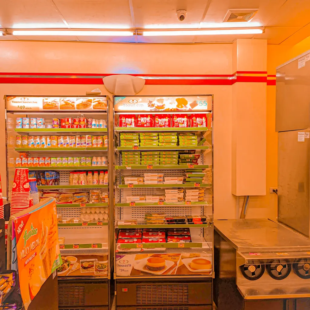 Refrigerated cases stocked with packaged food and drinks inside a convenience store.