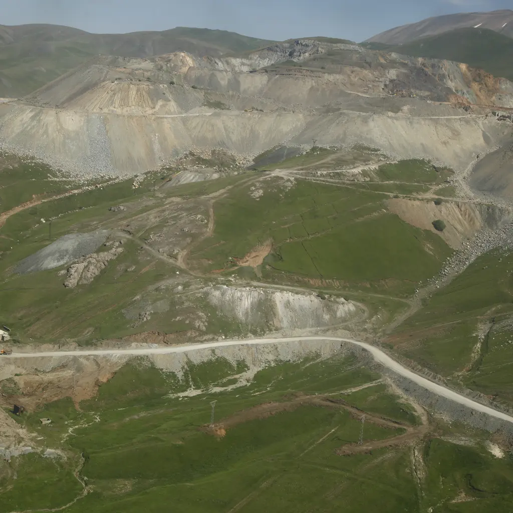 Benches and access roads carved into an open-pit gold mine.