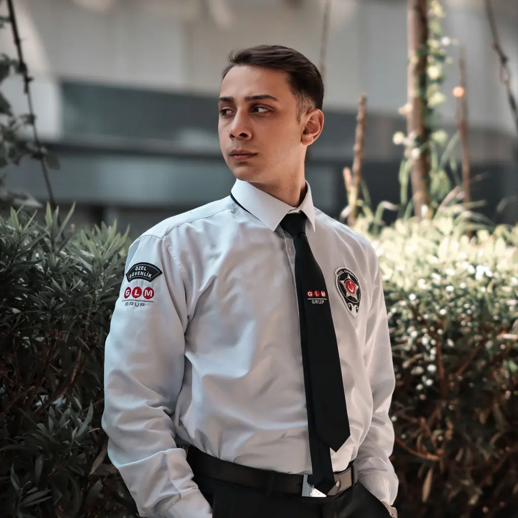 A uniformed private security guard standing outside a building.