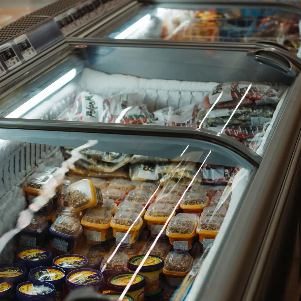 Packaged frozen desserts stacked inside a glass-topped freezer.