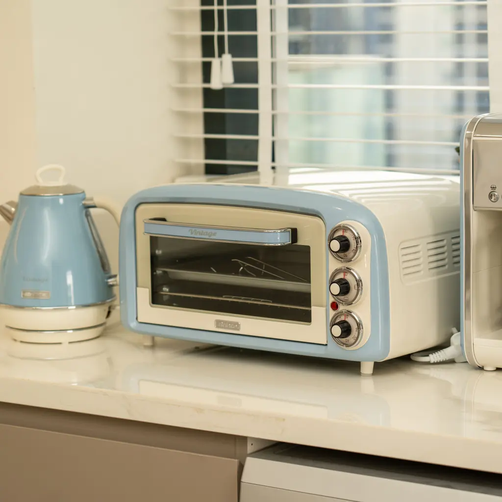 A small countertop oven and blue electric kettle on a kitchen counter.