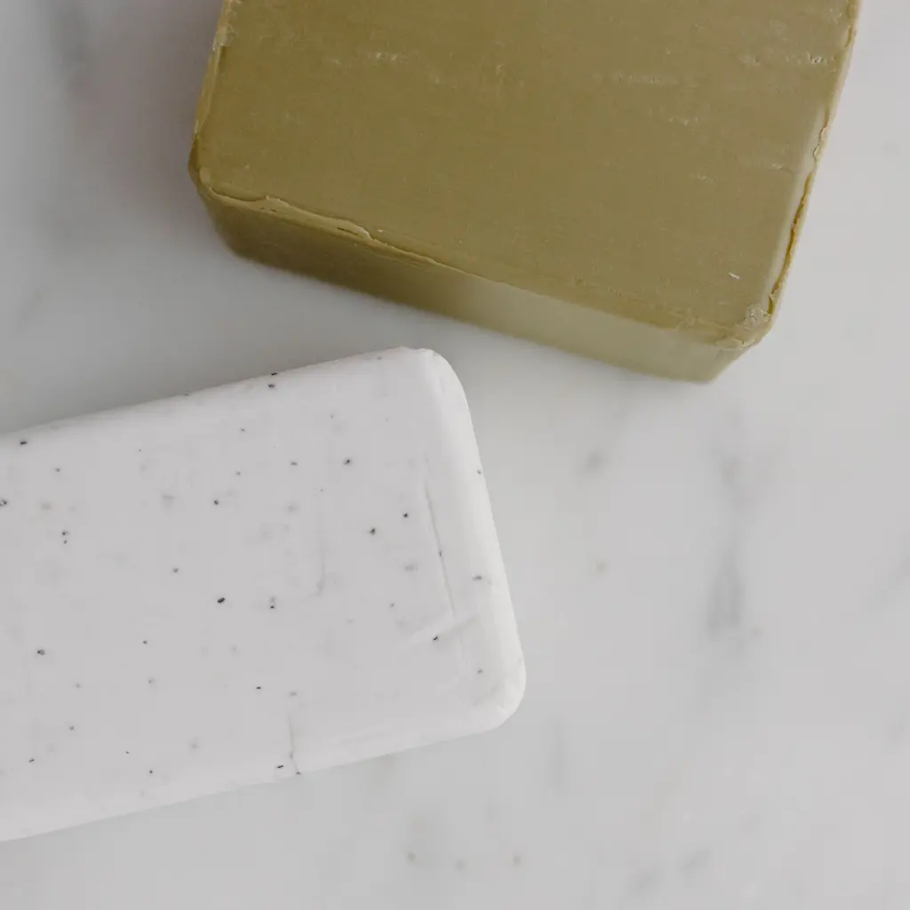 Rectangular green and white soap bars on a pale surface.