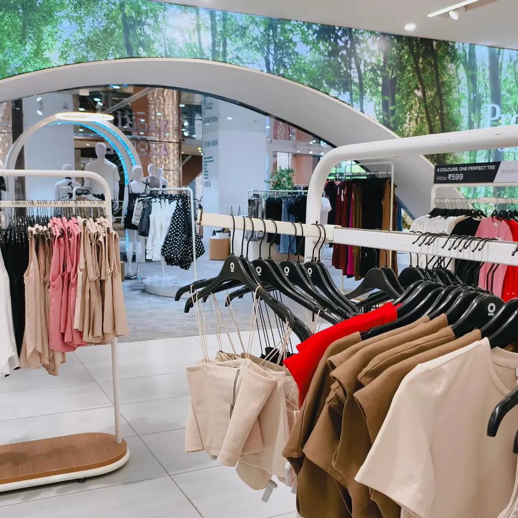 Racks of shirts, trousers and jackets arranged as clothing inventory indoors.