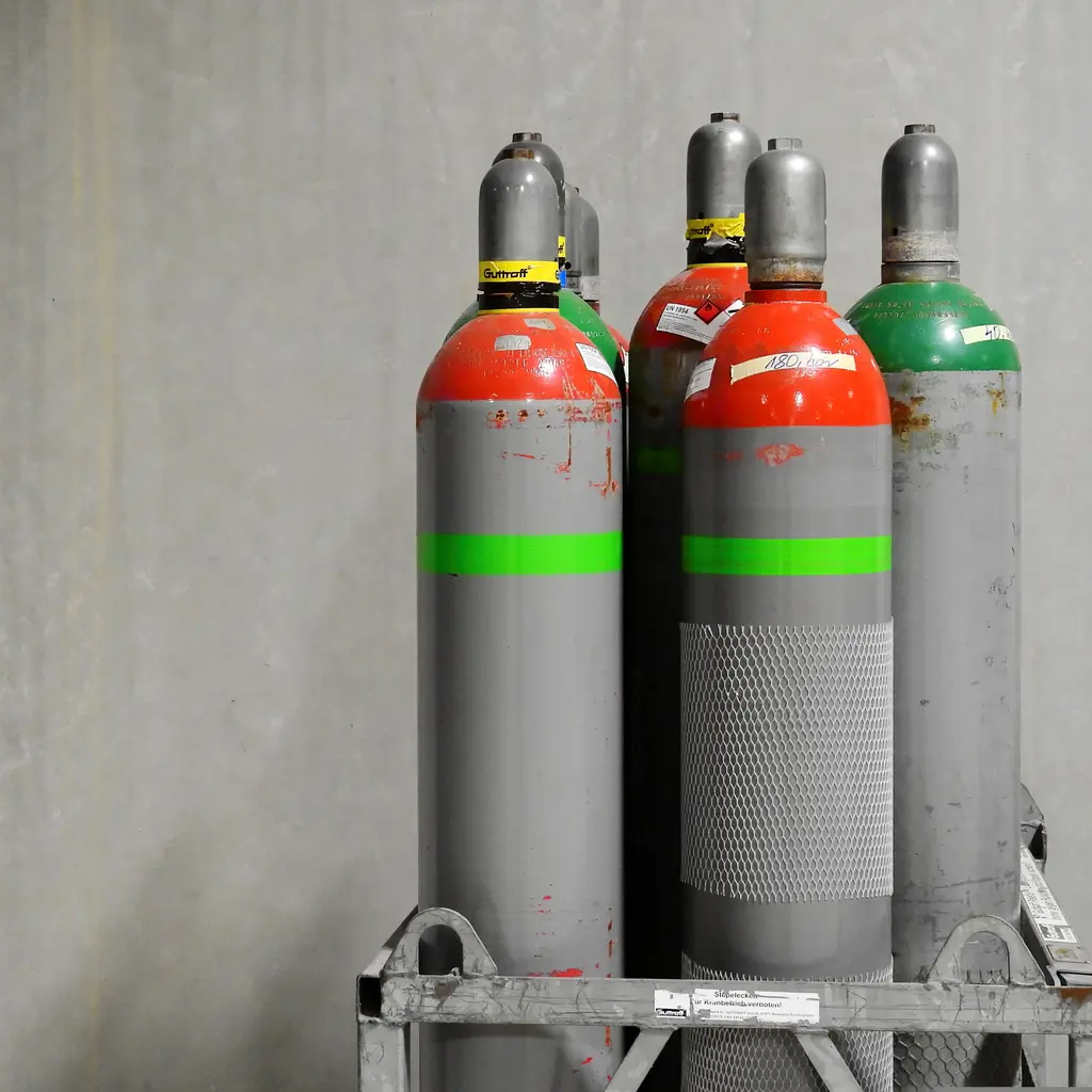 Capped industrial welding-gas cylinders held upright in a transport rack.
