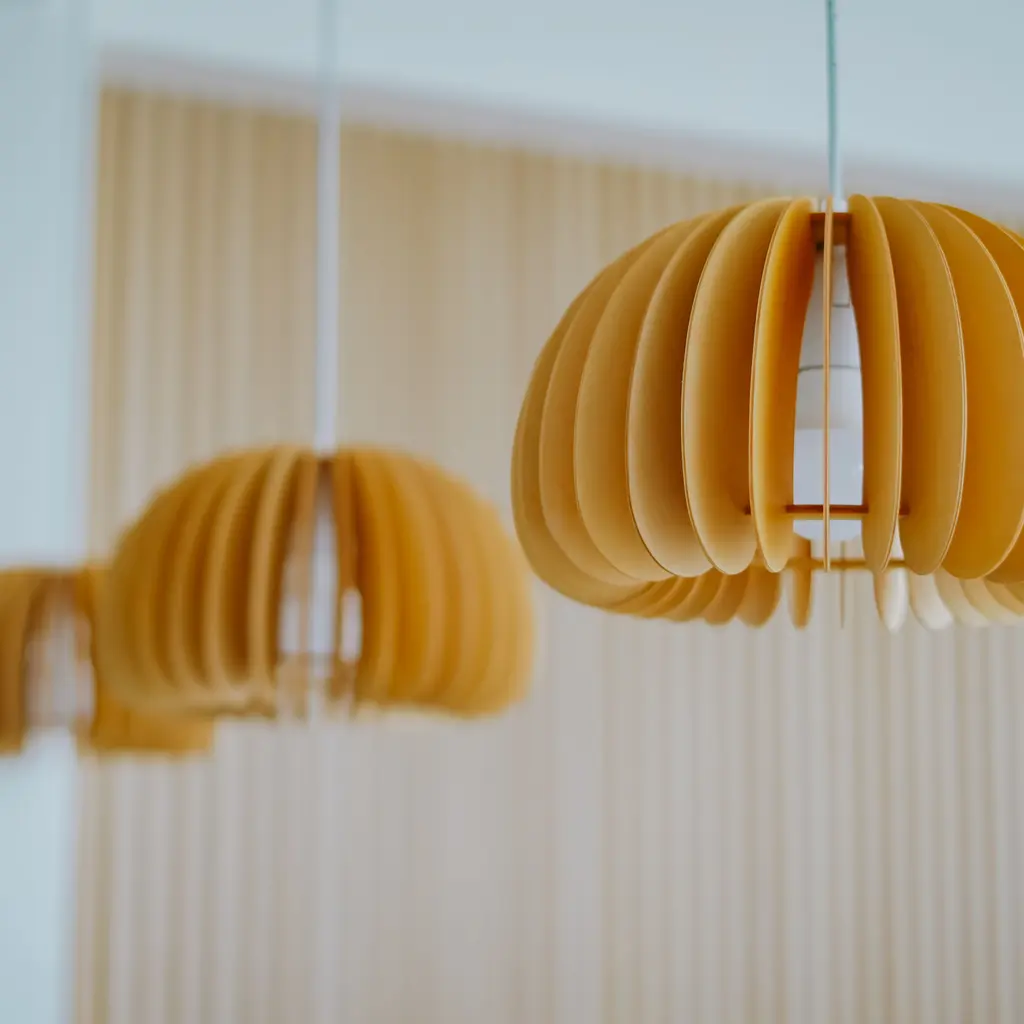 Sculpted wooden pendant light fixtures hanging at different heights indoors.