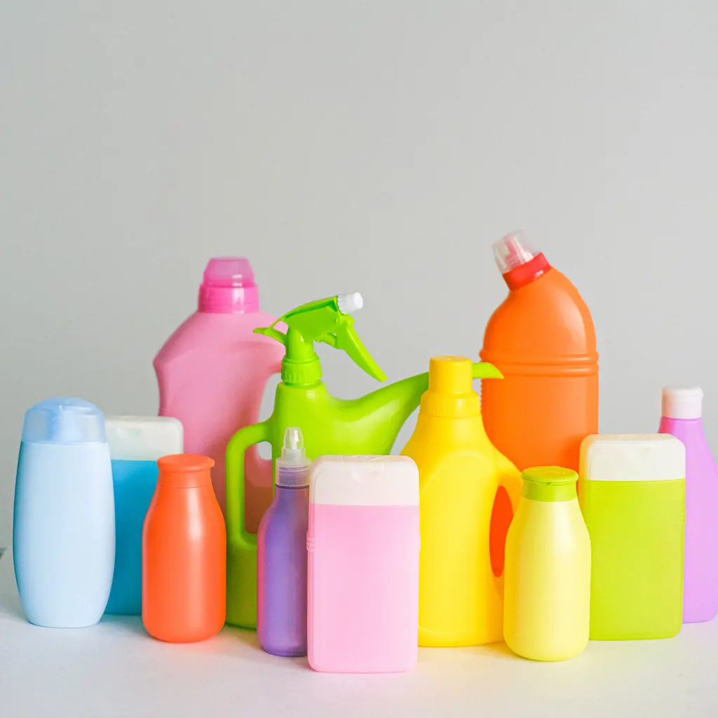 Colorful molded plastic cleaning-product bottles with screw caps and trigger sprayers.