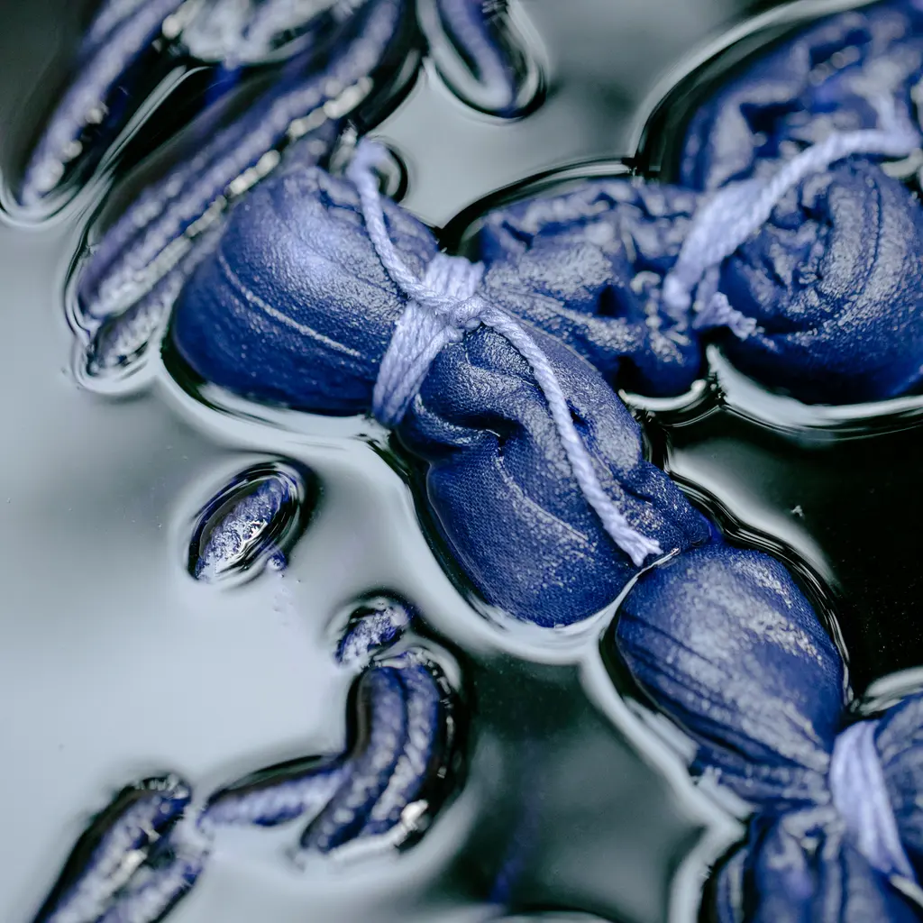 Tied blue fabric soaking in an indigo dye bath.