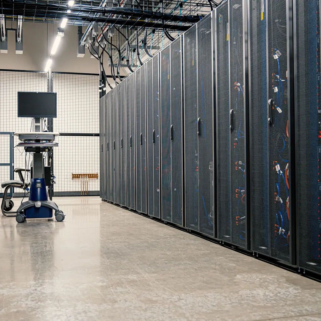 A row of enclosed server racks lines a data-center aisle.