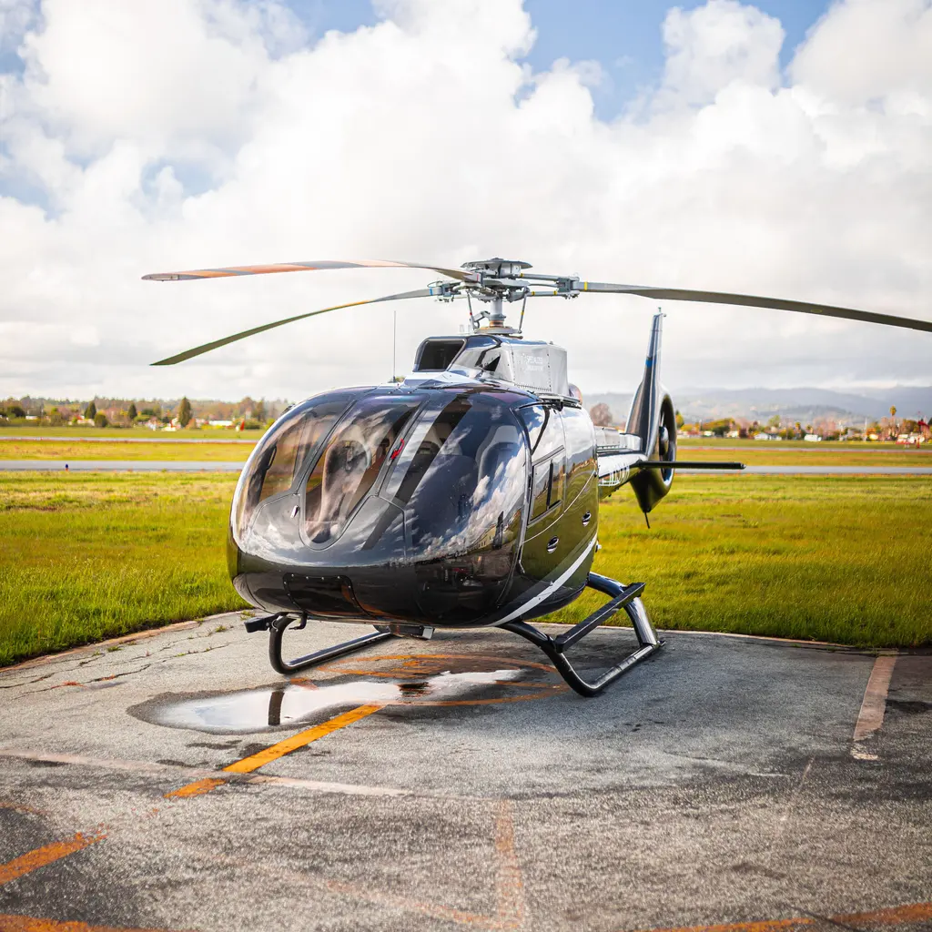 A civilian passenger helicopter parked on an airfield apron.