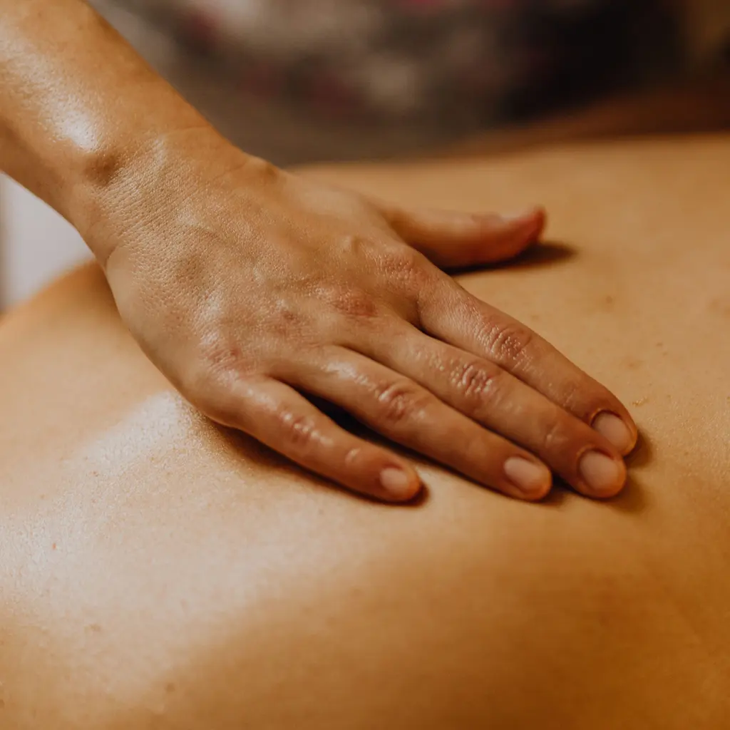 A hand giving a back massage.