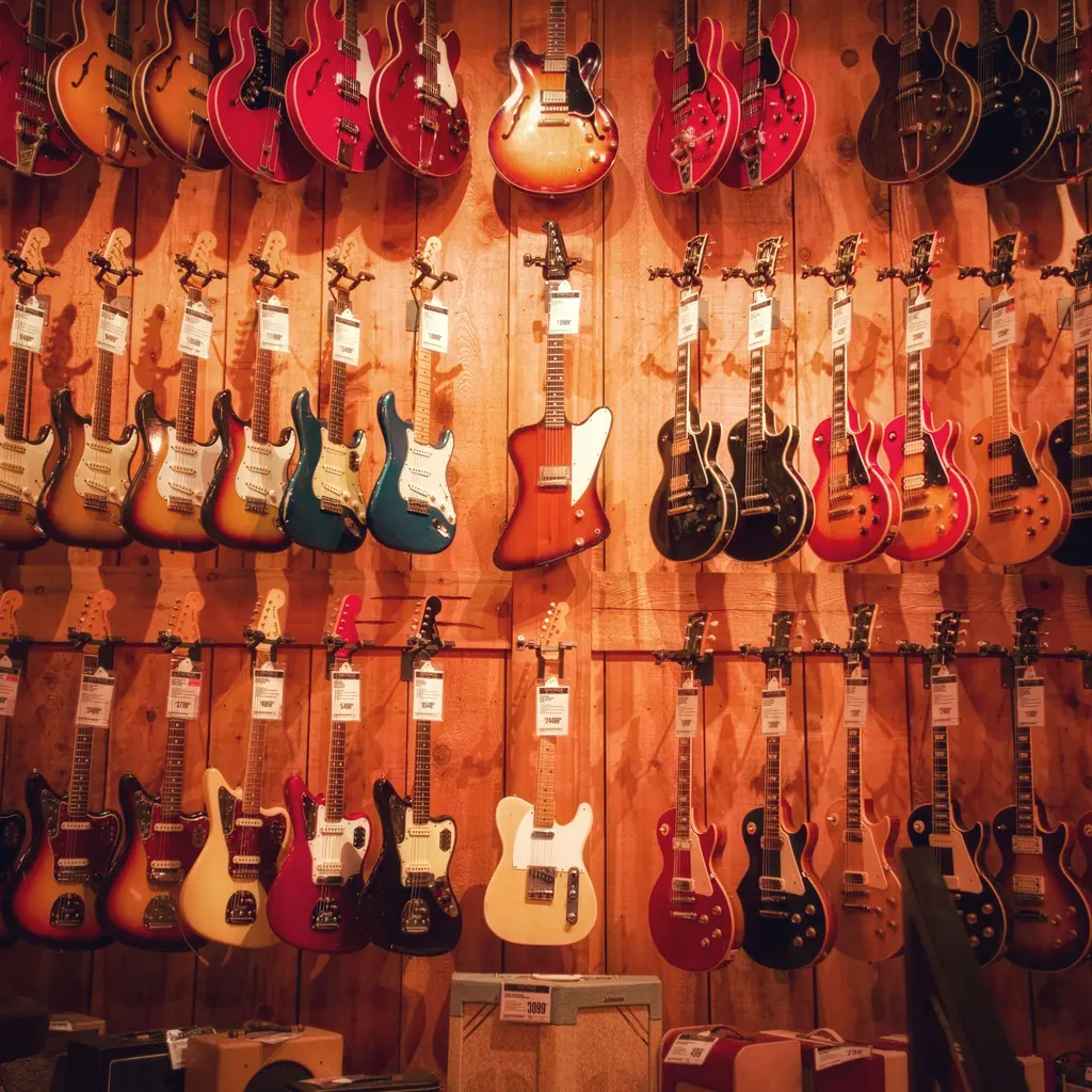 Price-tagged electric guitars hang in rows on a music-store display wall.
