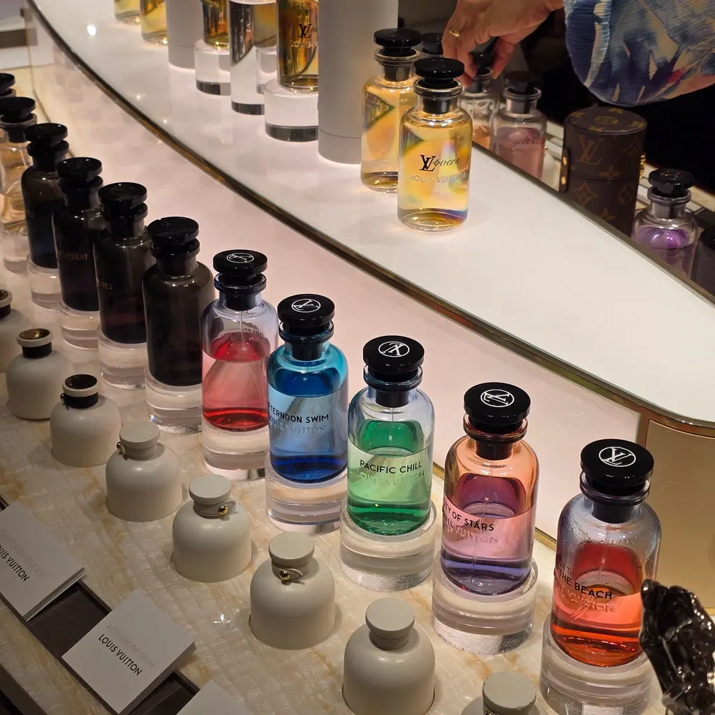 Rows of perfume bottles and sampling fixtures are arranged on a retail counter.