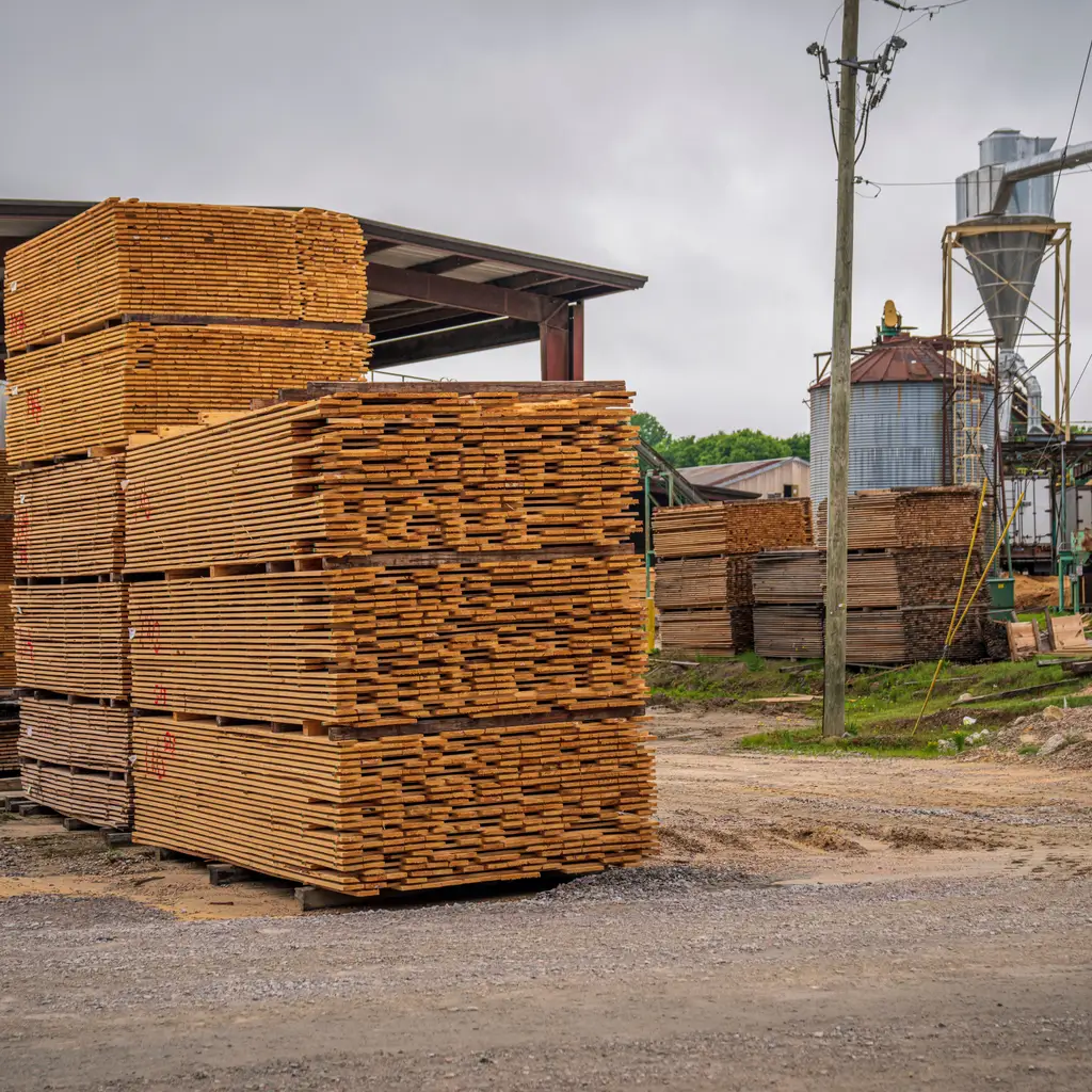 Sawn lumber is stacked in an outdoor mill yard.