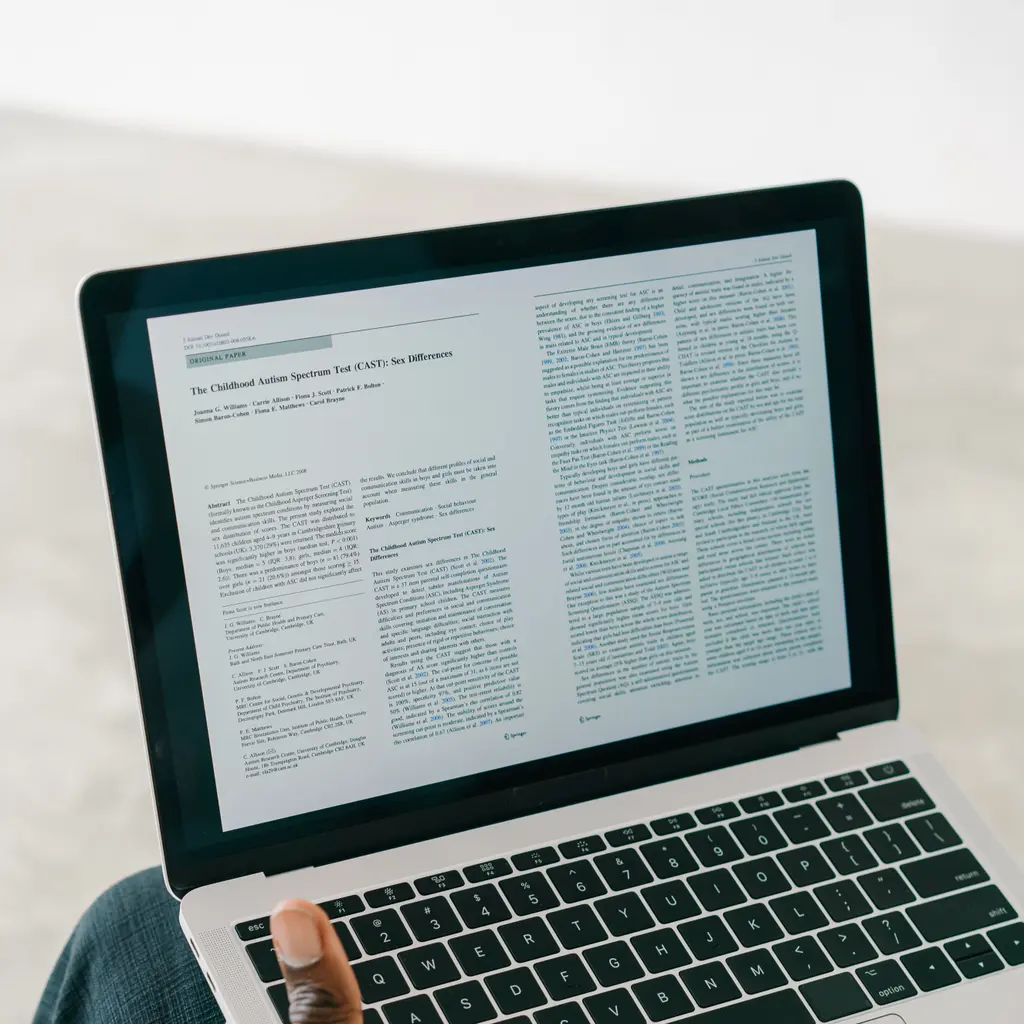 An academic research article displayed on a laptop.