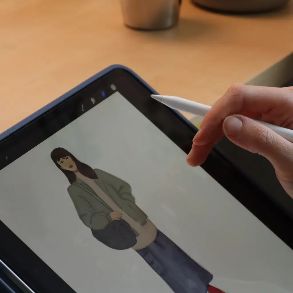 An artist using a stylus to draw a character on a digital tablet.
