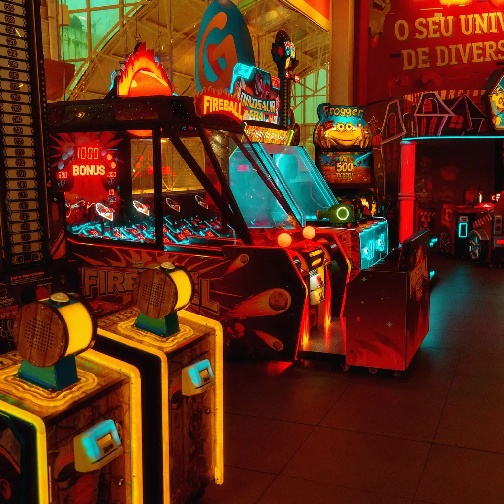 Colorful arcade machines with illuminated controls and game ramps.