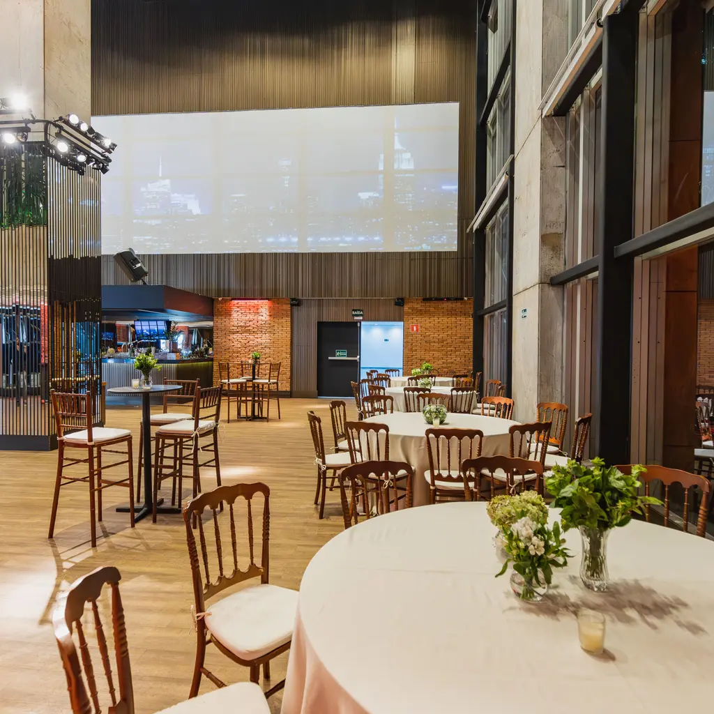 Dining tables and chairs arranged for a gathering in a function room.
