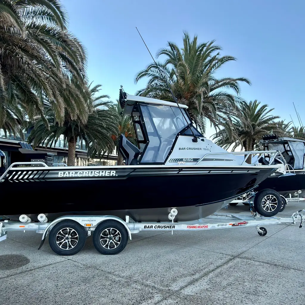 Outboard fishing boats displayed in a row on trailers.