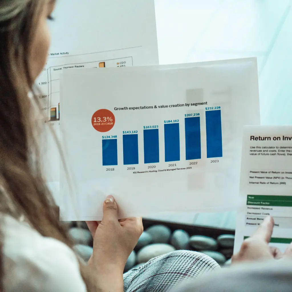 Investment-return reports being reviewed at a desk.