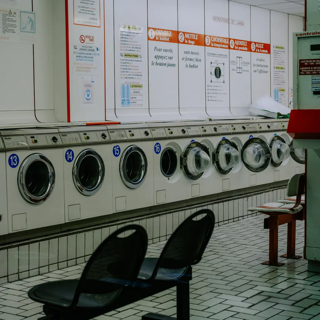 Commercial front-loading washing machines arranged in a row.