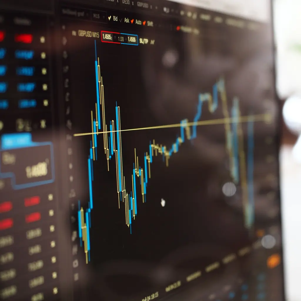A financial-trading monitor with candlestick charts and market quotes.