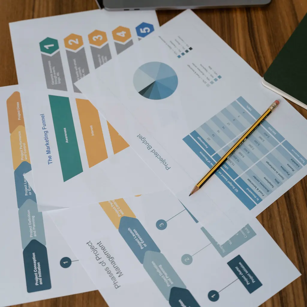 Printed project-management stages and planning diagrams on a desk.
