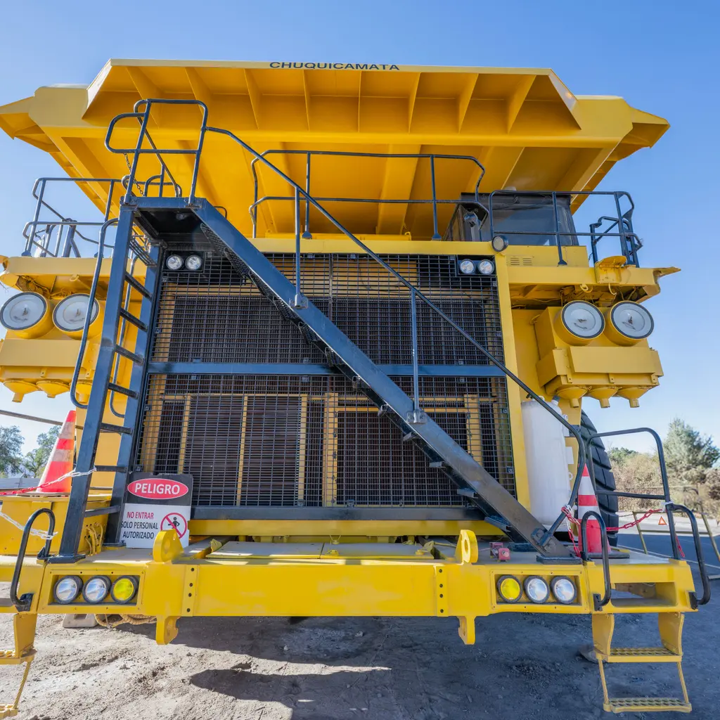 A large mining haul truck beneath a loading structure.