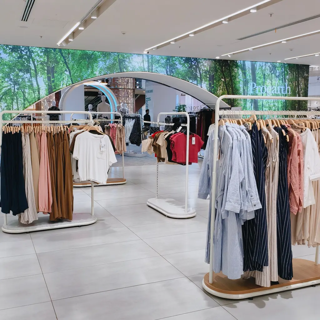 Clothing racks arranged across a spacious retail sales floor.