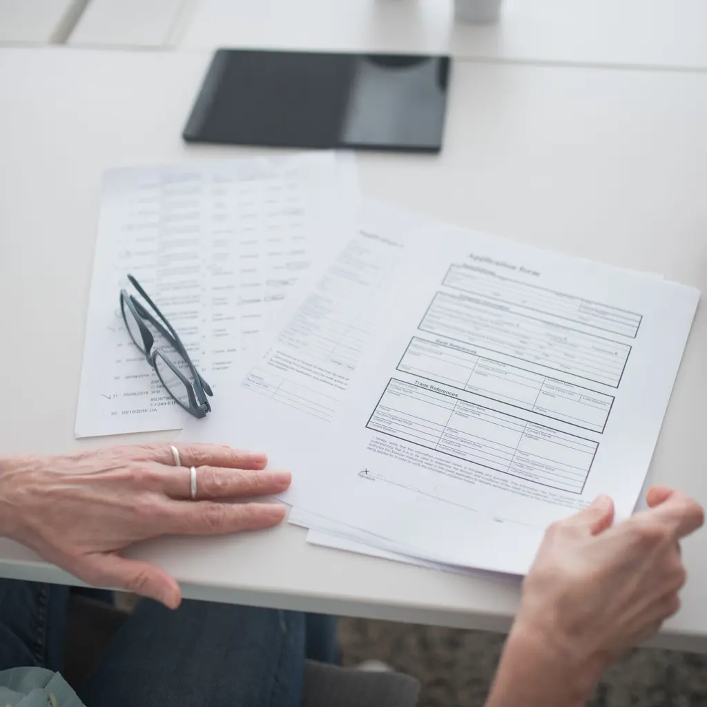 A printed application form being reviewed at a desk.