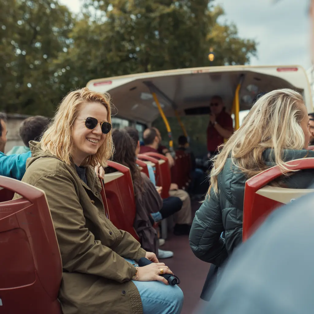 Passengers seated on the open deck of a sightseeing bus.