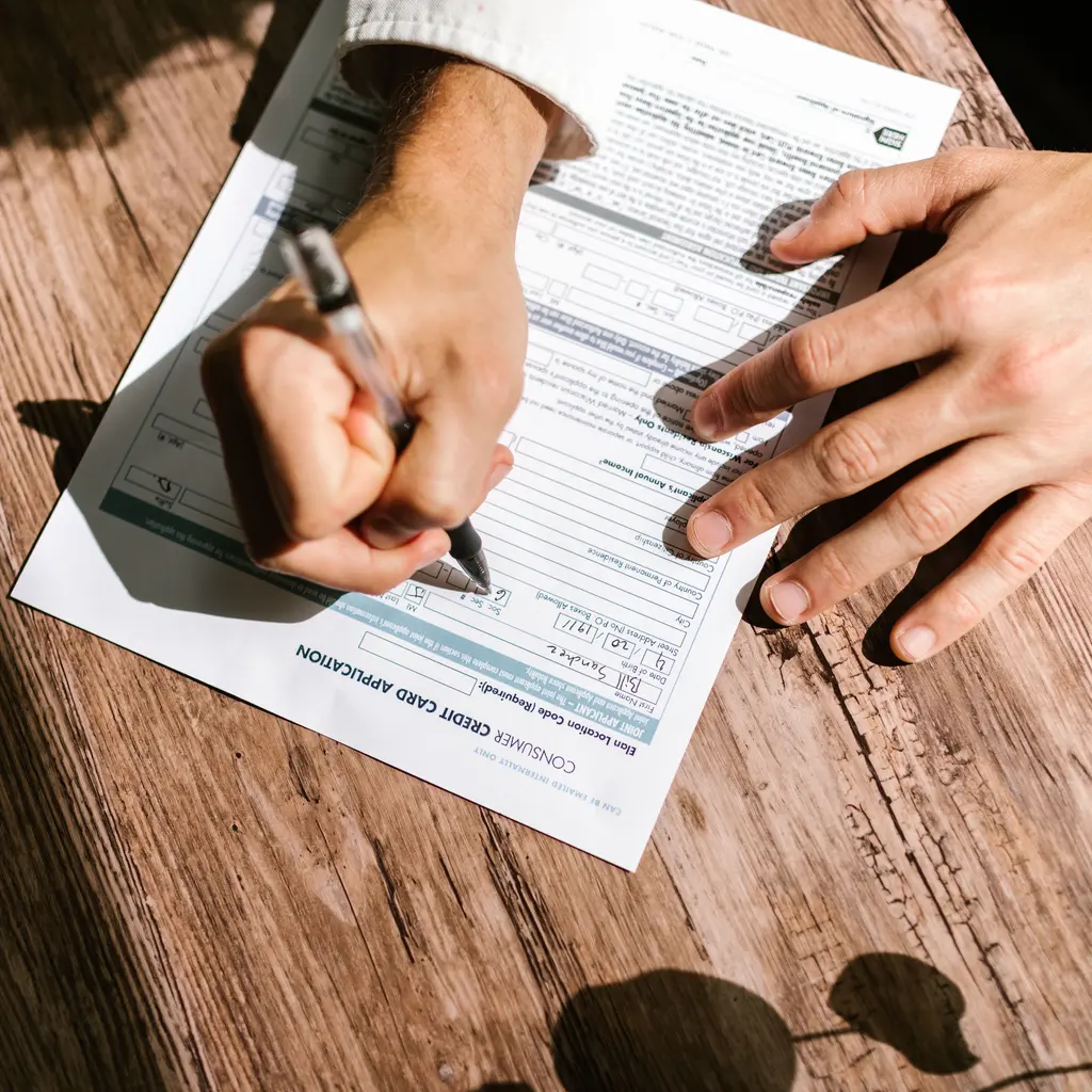 A consumer credit-card application being completed at a desk.