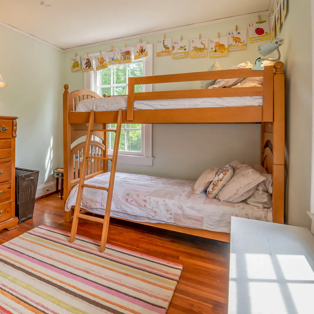 An empty child's bedroom with wooden bunk beds.