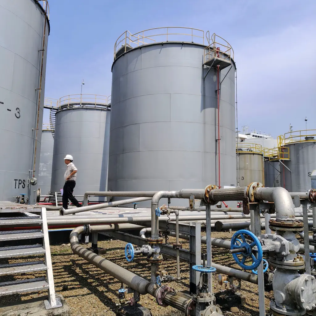Liquid-storage tanks, valves and transfer pipework at an industrial oil facility.