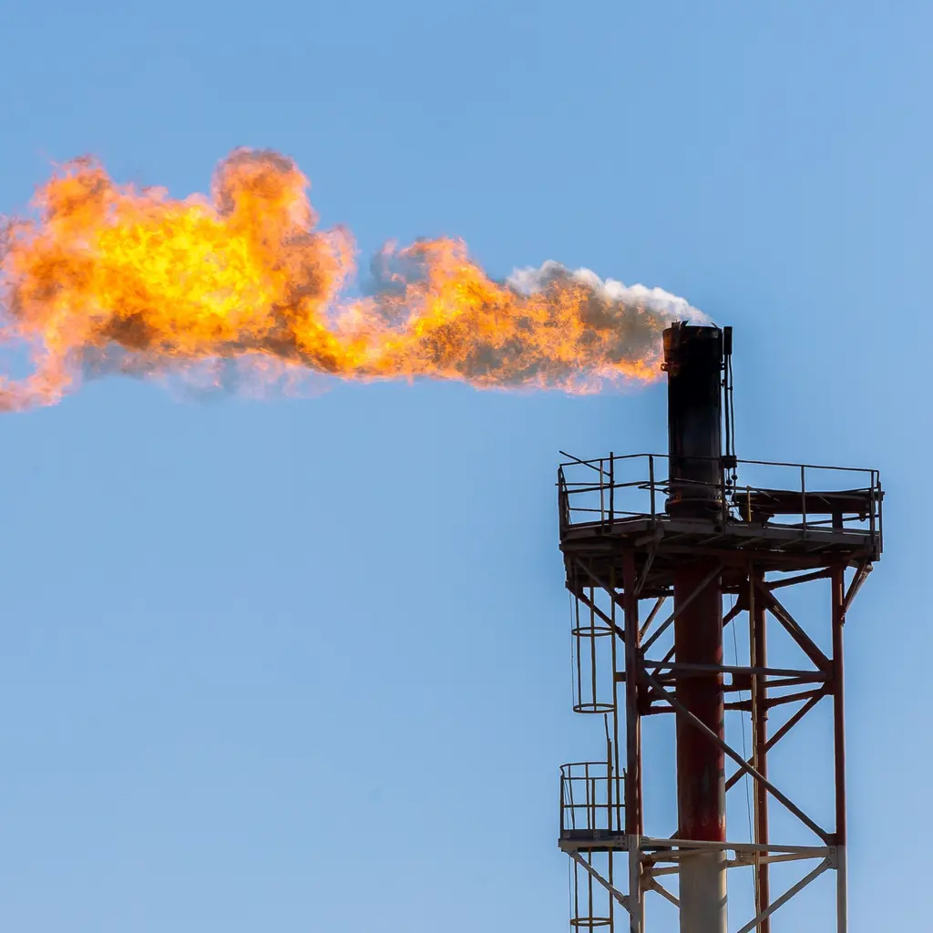 An industrial gas flare operating above a steel service platform.
