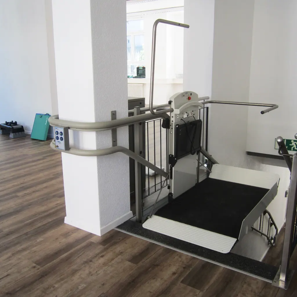 An indoor wheelchair platform lift and access railings.