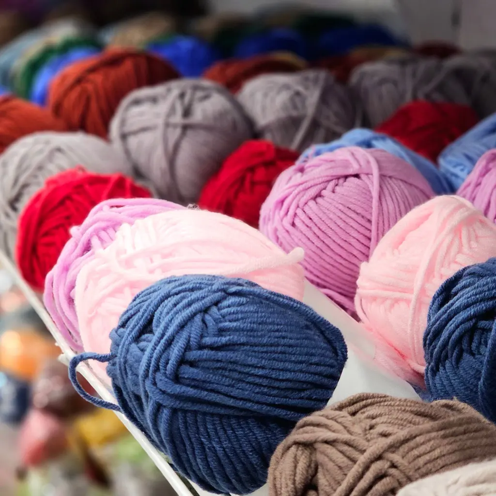 Balls of blue, pink, red and gray yarn arranged together on a display.