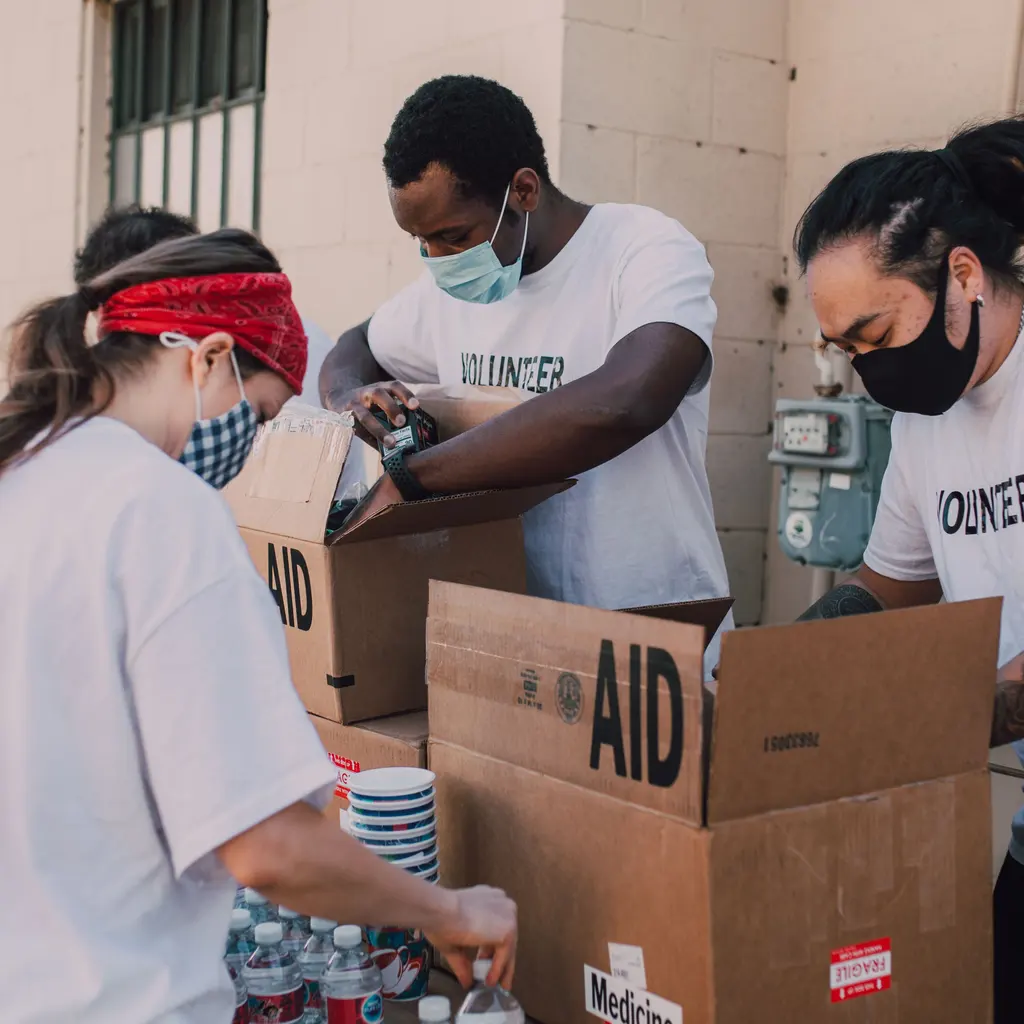 Volunteers packing food and water into aid boxes.