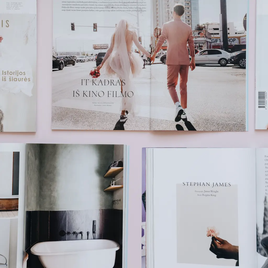 Printed magazines and open editorial spreads arranged on a surface.