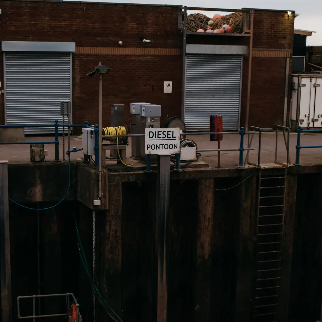 Fuel equipment and hoses above a dock marked Diesel Pontoon.
