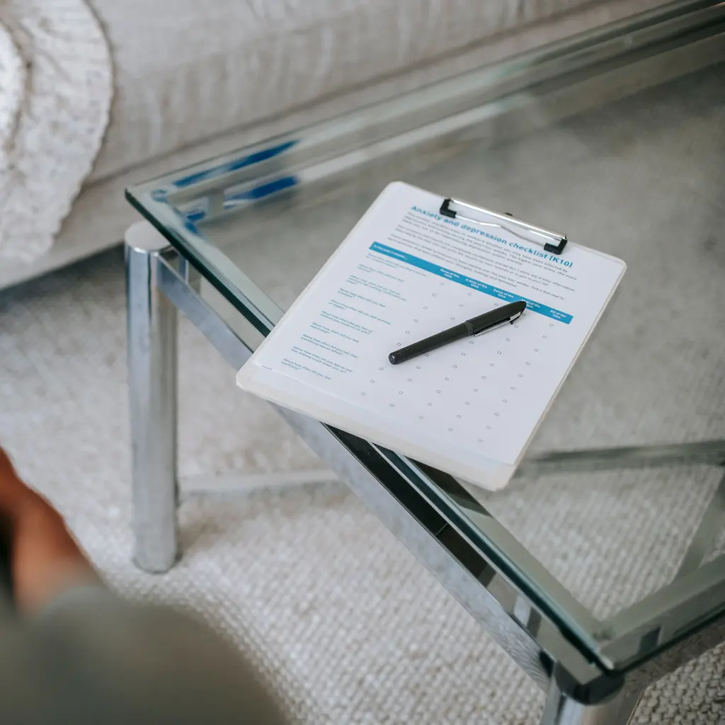 An anxiety-and-depression checklist and pen on a consultation-room table.