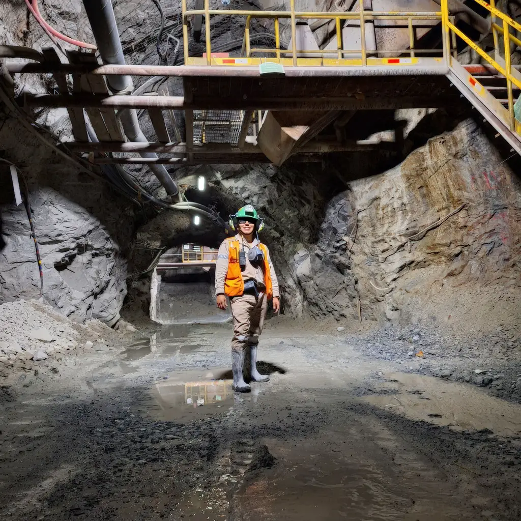 A hard-hat wearer standing in an underground mining passage.
