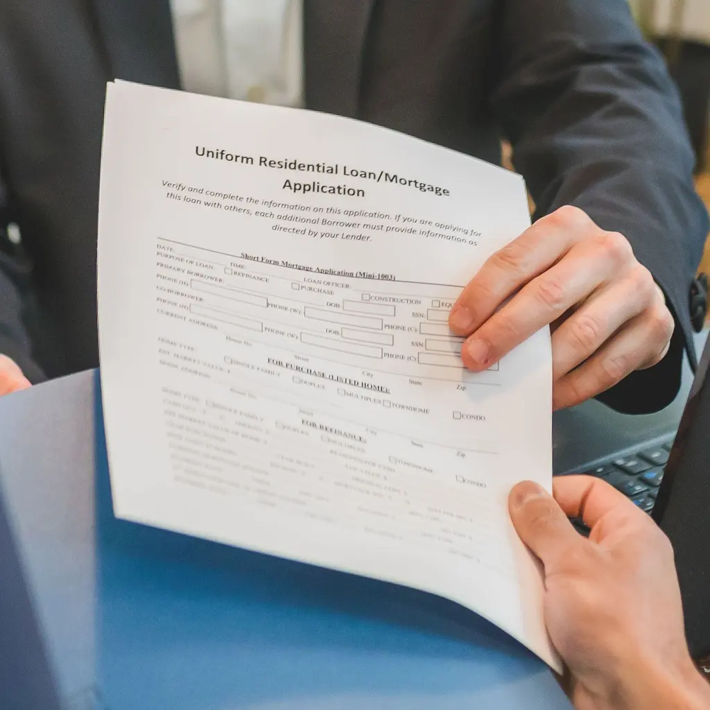 A residential mortgage application being reviewed in a document folder.