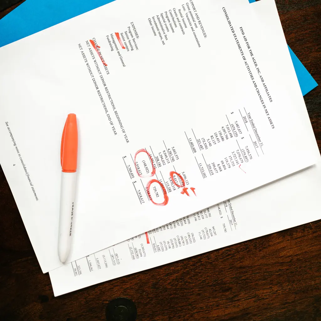 A nonprofit financial statement with handwritten review marks and a pen.